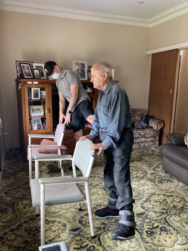 Mobile Physio and Older client doing standing hip abduction exercise